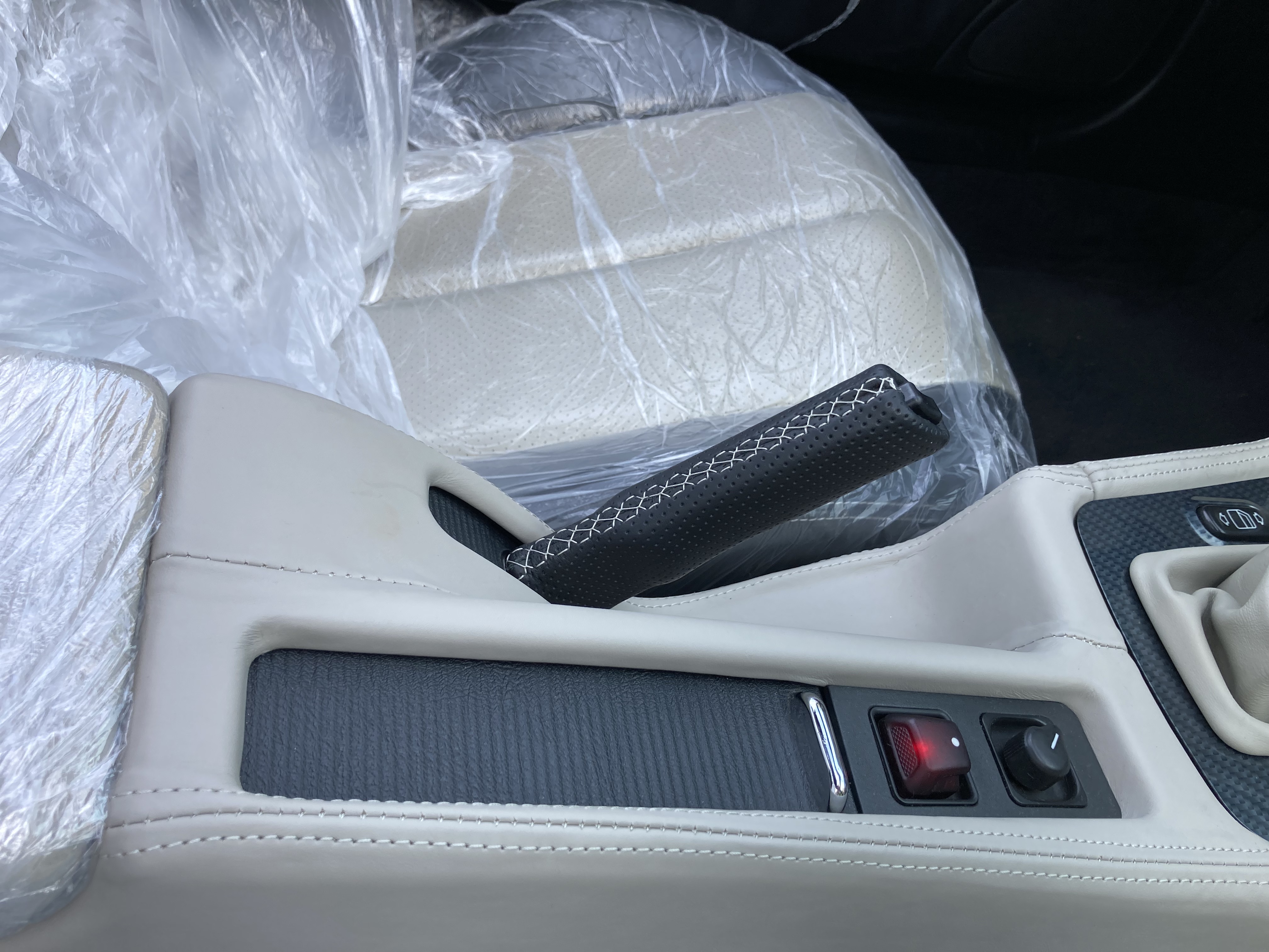 Handbremsgriff des Mercedes-Benz SLK 170, aus echtem perforiertem Leder gefertigt, mit handgenähter Naht. Die Nähte sind in der Originalfarbe des Fahrzeugs abgestimmt.